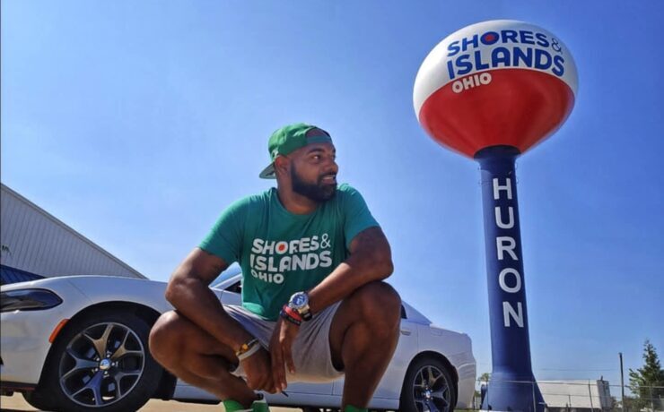 6 Kids 1 Tank Mike Mixon standing in front of a water tower in Huron, Ohio's Shores and Islands